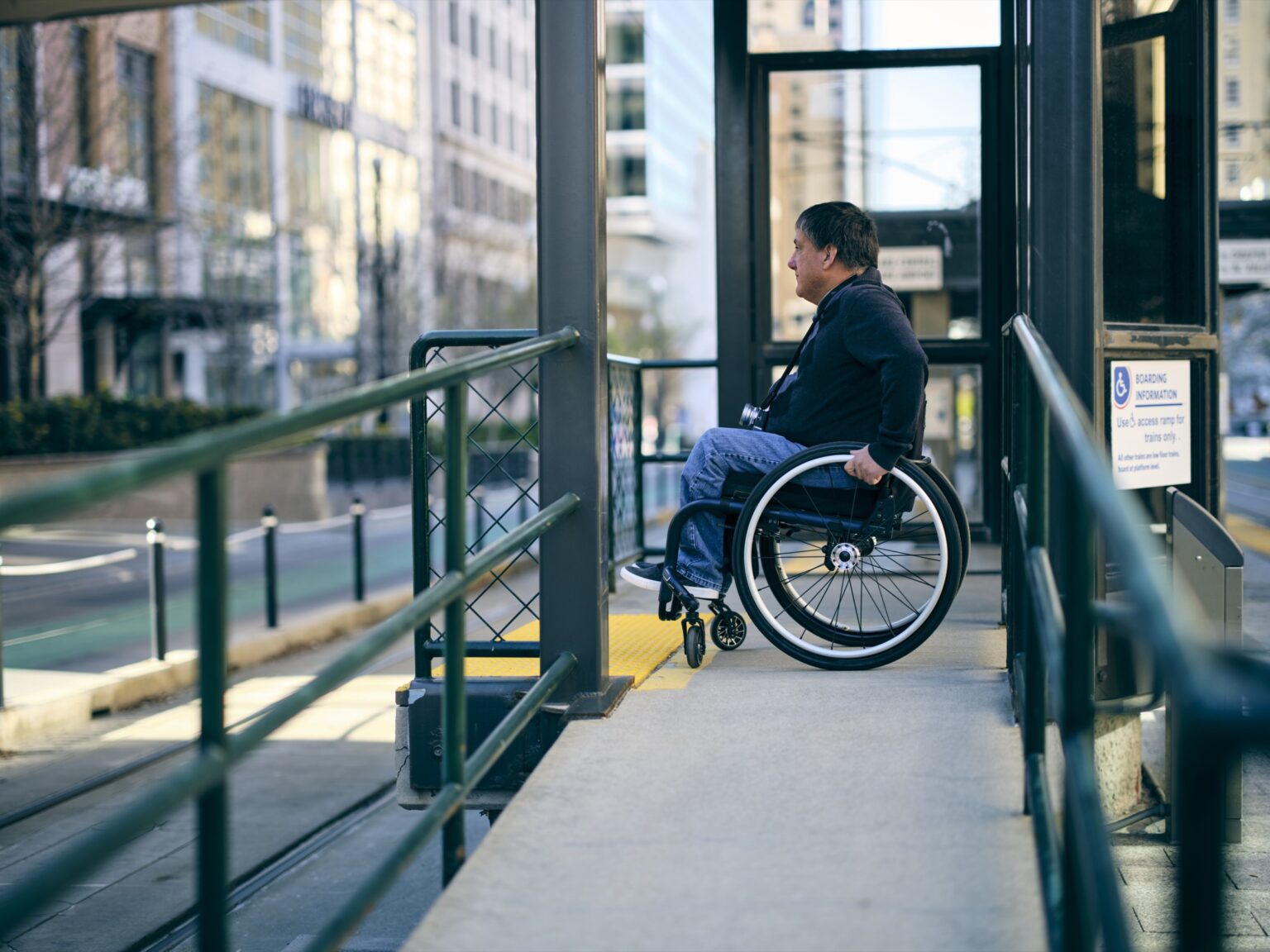 A disabled man, using a ramp with his wheelchair.