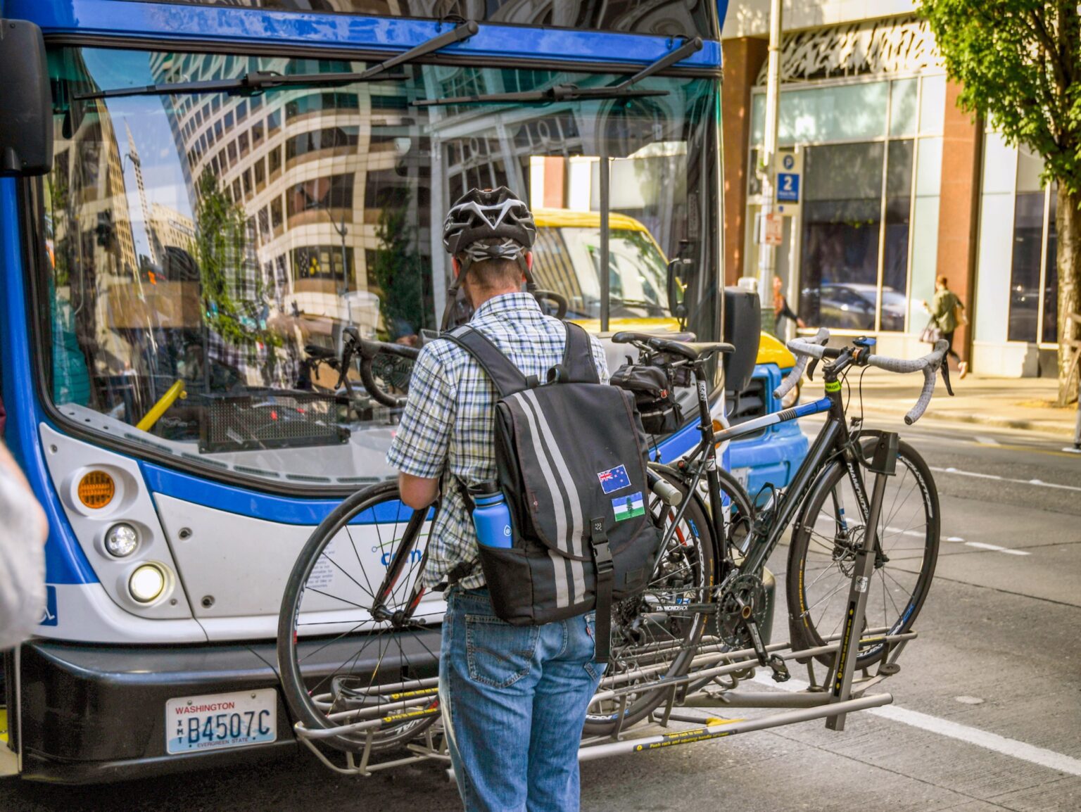 Commuter attaching his bike to the front of a bus in Seattle