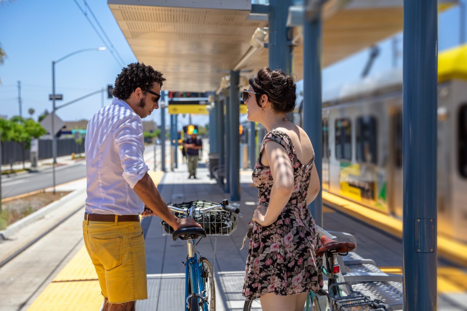 Two people talking at a rail station with bikes