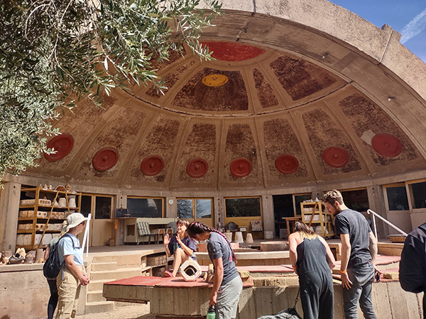 People in the foreground of a large domed structure at Arcosanti Credit HDR
